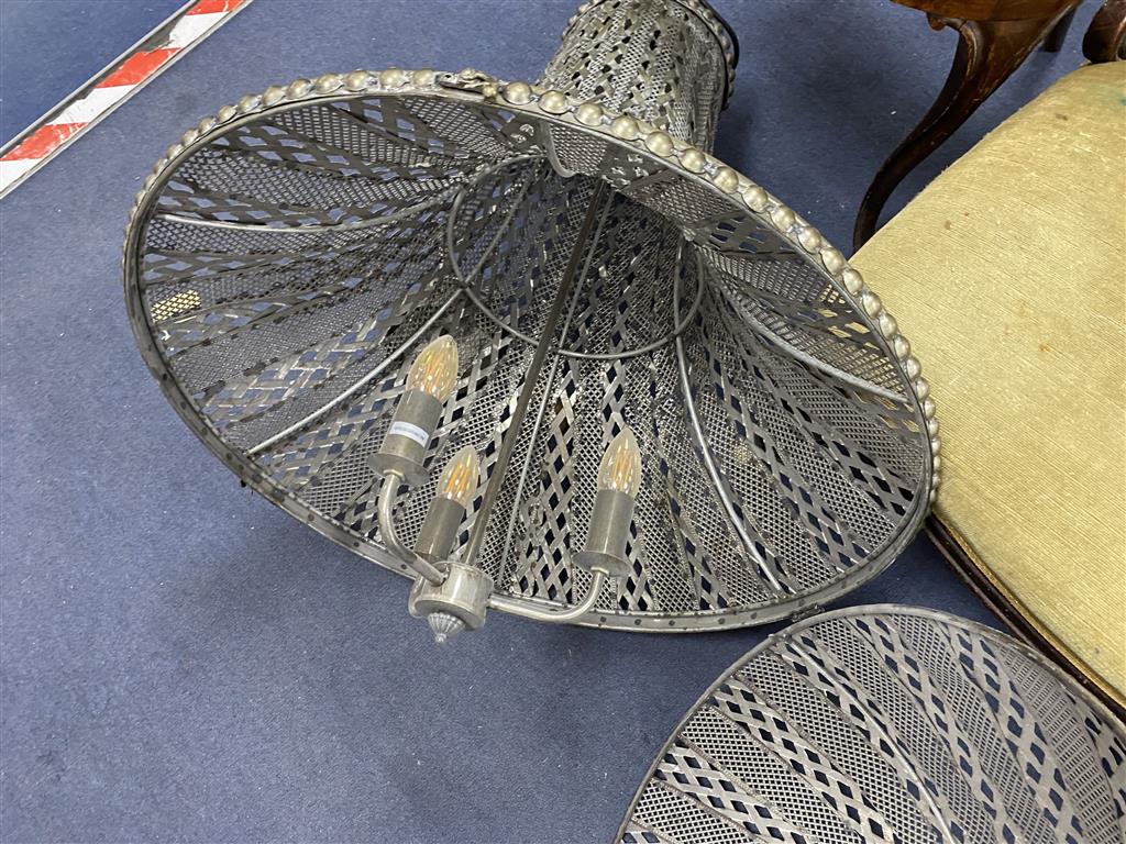 A large pierced metal ceiling shade